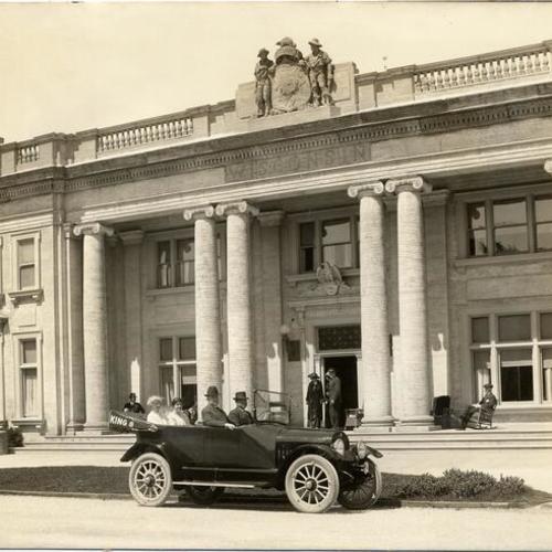 [Four people in a car in front of the Wisconsin State Building at the Panama-Pacific International Exposition]