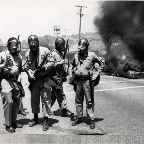 [National Guardsmen wearing gas masks on Berkeley street near University of California campus]
