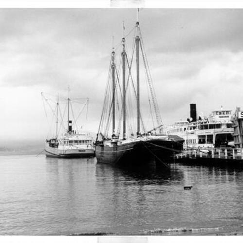 [View of the Hyde Street Pier from the shore, with the schooner Thayer and the ferry Eureka docked at the pier]