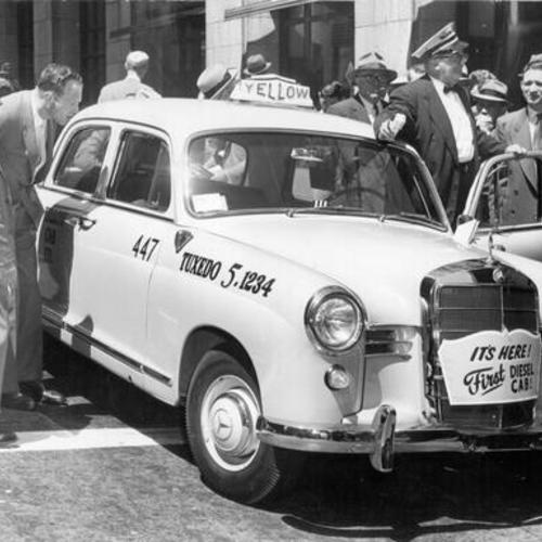 [Tom Corey showing a diesel-engine taxicab to a crowd of people at Montgomery and Bush streets]