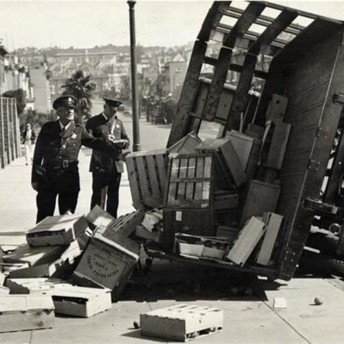 [Police inspecting a produce truck overturned near Geary Street]
