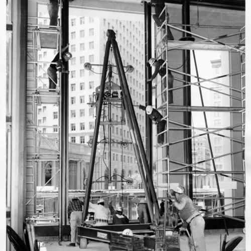 [Workers installing a large pane of glass in the Standard Oil Company building at 555 Market Street]