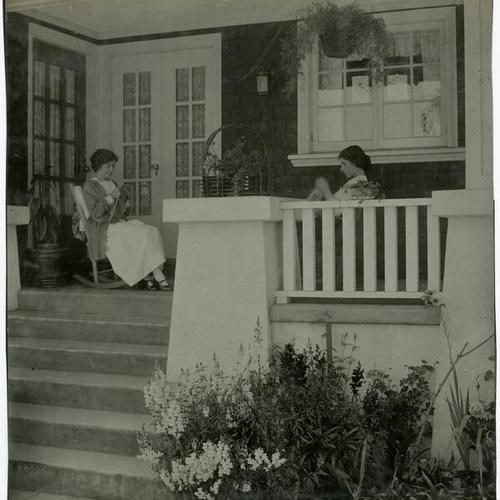 [Two women knitting on the front porch of a house in Westwood Park]