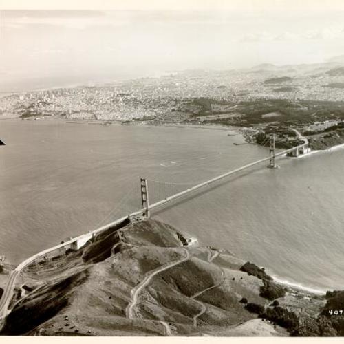 [Aerial view of the Golden Gate Bridge from over Marin County, looking toward San Francisco]