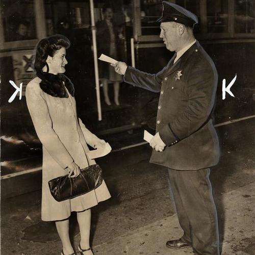 [Officer Harold F. Winkler handing ticket to Ms. Ethel Flanagan]