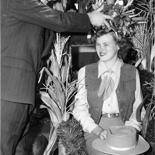 [Municipal Judge Edward Molkenbuhr placing a crown on Velma Beasley, queen of the third annual Farmers Market Fiesta]