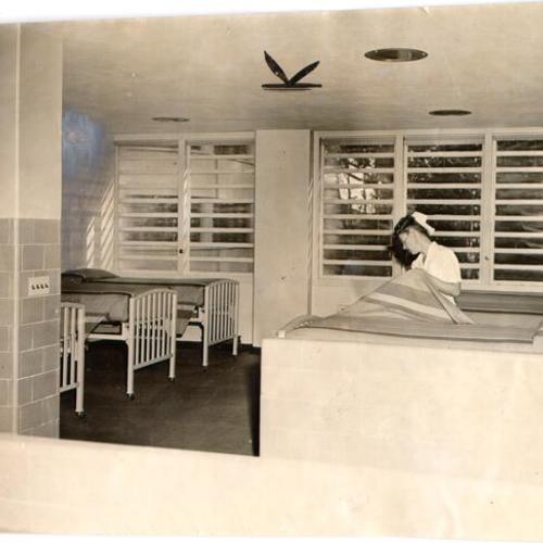 [Superintendent of Nurses Corinne Parsons making a bed in a ward at Langley Porter Clinic]
