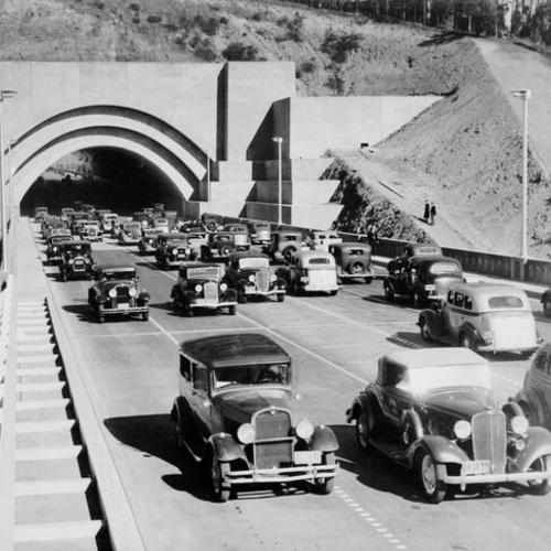 [Procession of vehicles driving through Yerba Buena Island tunnel on opening day of San Francisco-Oakland Bay Bridge]