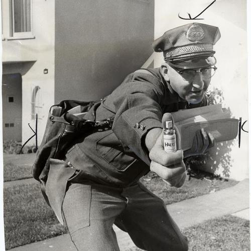 [Mail carrier Bill Mooney showing a new experimental spray against barking and biting dogs]