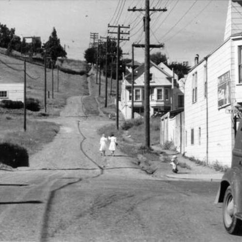 [Two girls walking down a dirt road in Visitacion Valley]