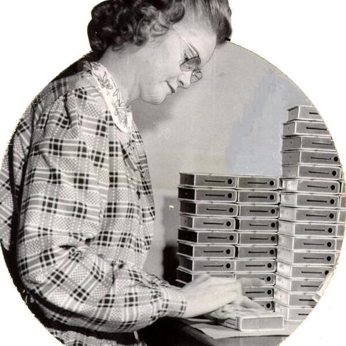 [Hazel Gibson, of Bankers Utilities Company, polishing a popular design of a bank resembling a book]