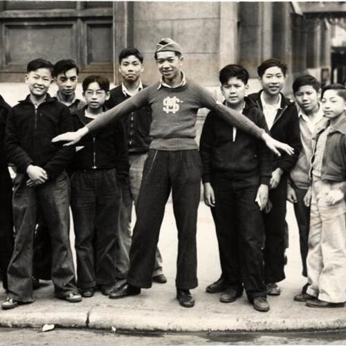 [Captain James Der, of the Chinese Junior Traffic Patrol, with a group of students]