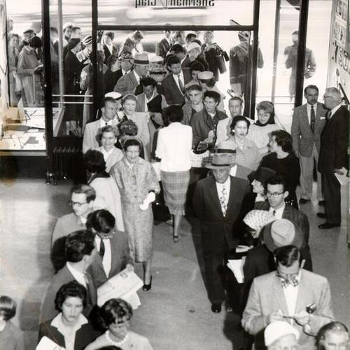 [Crowd of people lined up to buy opera tickets at Sherman & Clay box office]