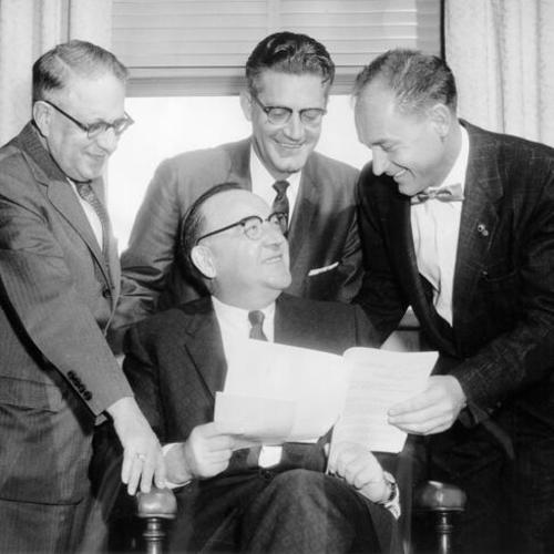 [Charles Mitchell (left), Police Chief William Faulstich (center) and Mayor William Royer of Redwood City (right) confer with Attorney General Edmund G. Brown (seated)]