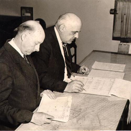 [Chief Wharfinger William P. Geary and David P. Batiloro looking over docking schedules]