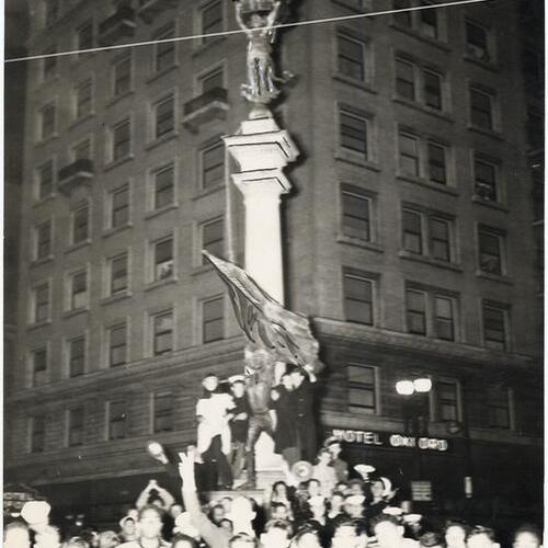 [Crowd celebrating news of Japan's surrender at Native Son's monument]