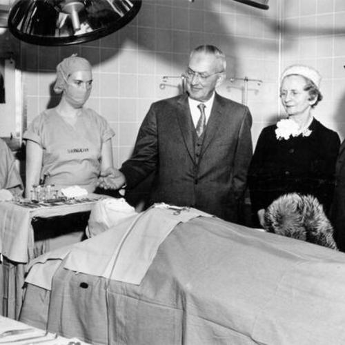 [Group of people inspecting an operating room at St. Francis Memorial Hospital]