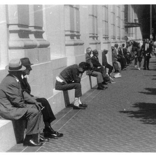 [People sitting outside the Bank of America branch at Powell and Market streets]