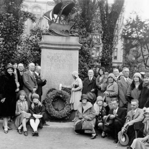 [Group of unidentified people placing a wreath on the Robert Louis Stevenson monument]