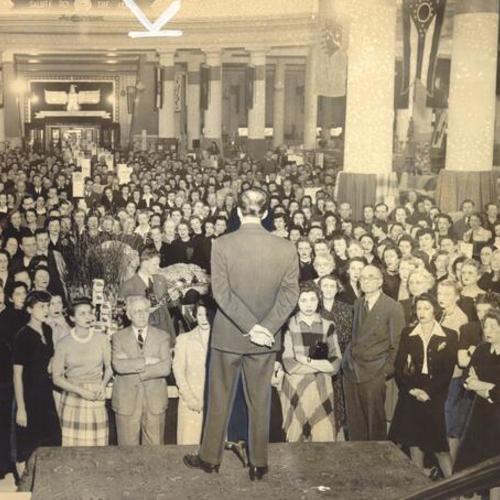[William B. Reagan Jr. addressing employees of the Emporium at a defense bond rally in the store]