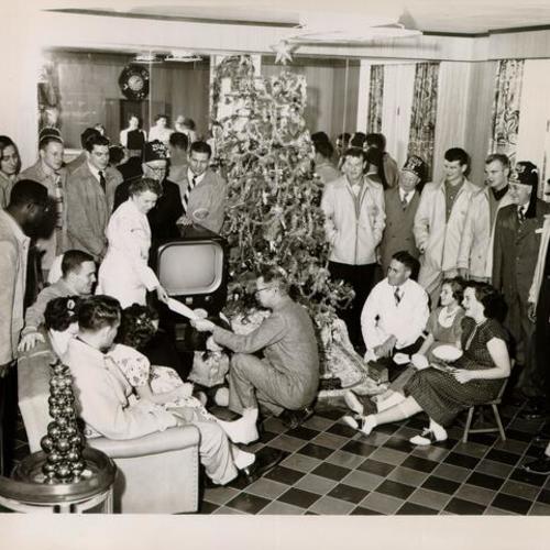 [Group of people gathered around a Christmas tree at Shriners' Hospital for Crippled Children]