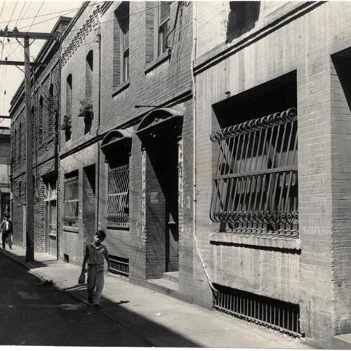 [Young boy walking along Beckett Alley in the Chinatown district]