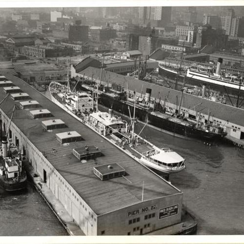 [Aerial view of ships docked at waterfront]