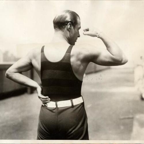 [Rudolph Valentino flexing his arm to show musclular development]