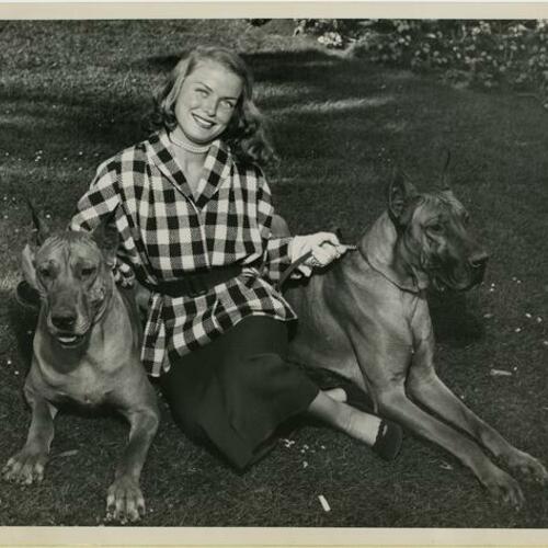 Patricia Sheenan sitting on grass with two dogs