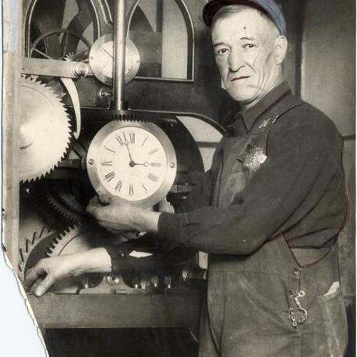 [Unidentified technician working with machinery inside Ferry Building clock]