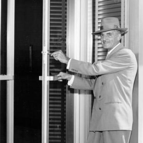 [Unidentified man opening the door of the Stonestown branch of Bank of America]
