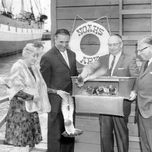 [Mayor George Christopher, Phyllis Diller, Carey Baldwin and Cyril Magnin releasing doves in celebration of the opening of Noah's Ark at Fisherman's Wharf]