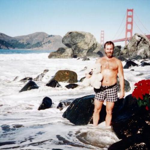 [Man on Baker Beach on Christmas Day with Marin Headlands and Golden Gate Bridge in background]