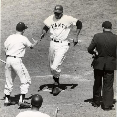 [Willie McCovey crossing home plate after hitting his second home run of the day]