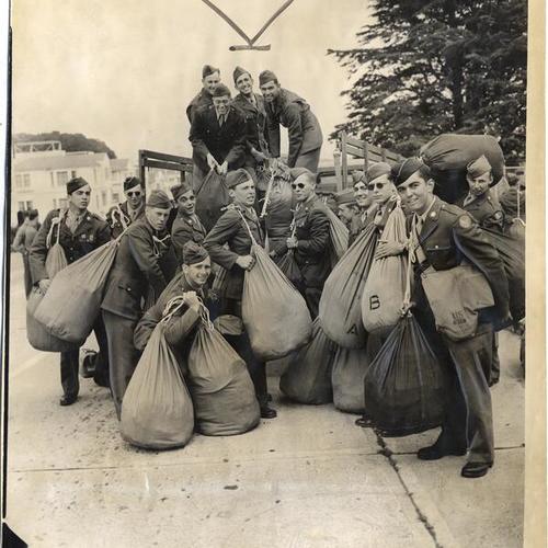 [Group of U. S. Army pre-engineering students unloading duffel bags from a truck at the University of San Francisco]