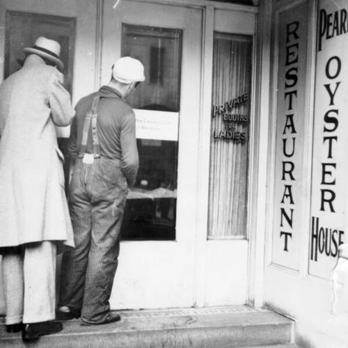 [Two men standing at the entrance to the Pearl Oyster House]