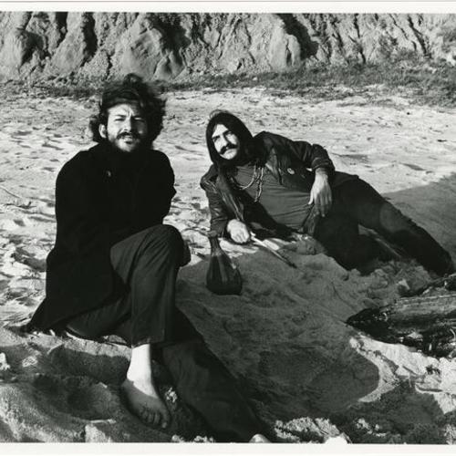 [H. G. and Tom Mazzolini laying on the beach]