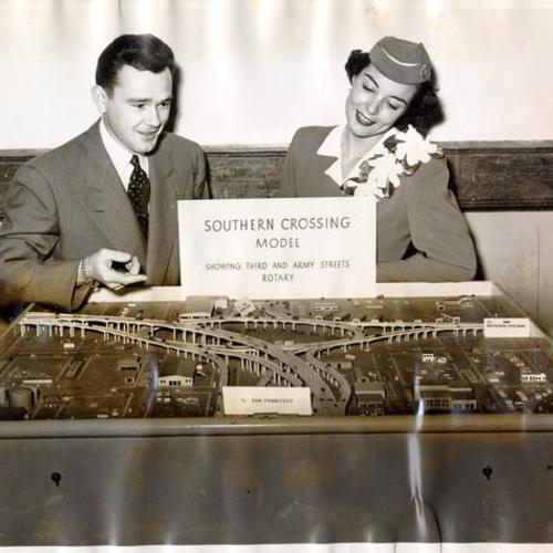 [Ted Taylor and Jean Glick, American Airlines hostess, using the model of Southern Crossing bridge to discuss its advantages]