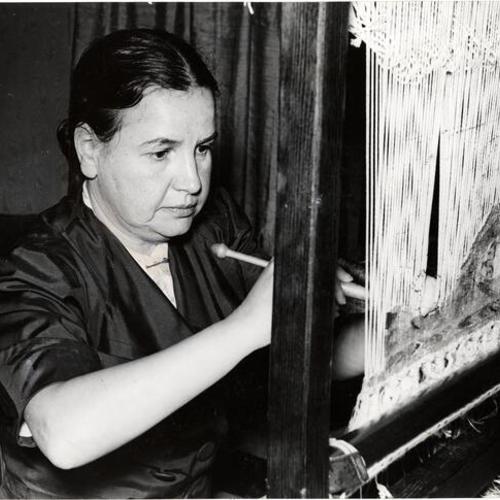 [Tilli B. Lorch working on one of her small looms demonstrating medieveal tapestry techniques]