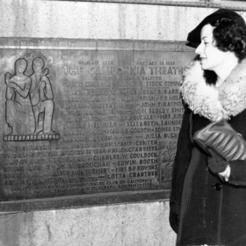 [Gwendlyn Blanco standing in front of a plaque commemorating the California Theatre]