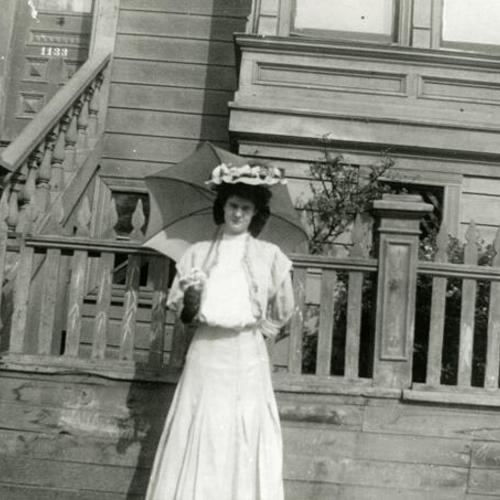 [Portrait of a woman in front of house on Treat Street]