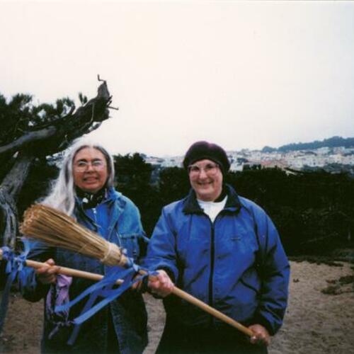 [Maxine Spencer and Polly Taylor posing with broomsticks for Broomstick Magazine's 10th anniversary]