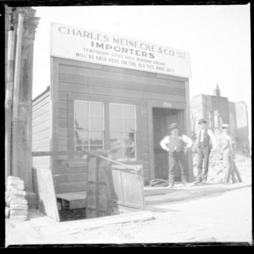 [Three men standing outside of the Charles Meinecke and Co. Importers building]