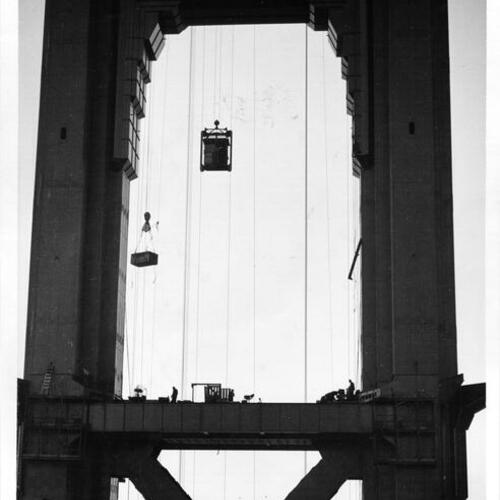 [Marin tower of Golden Gate Bridge under construction with San Francisco in background]