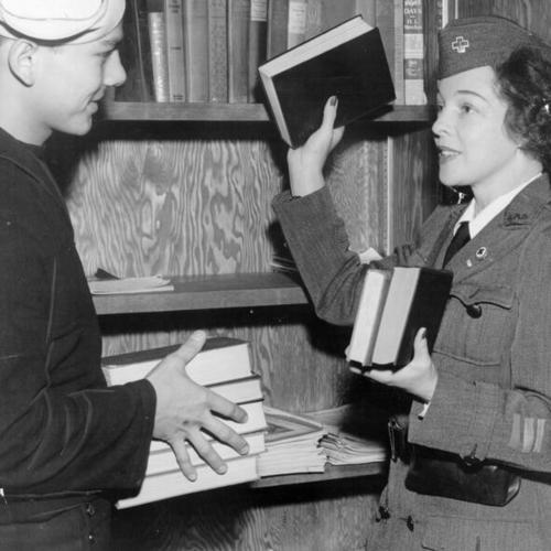 [Arnold Tracy and Mrs. Dan London stocking library shelves in the new "room within a room"]