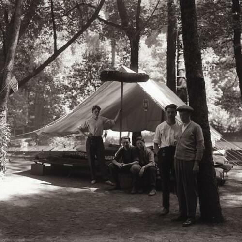 People gather outside their tents at Camp McCoy