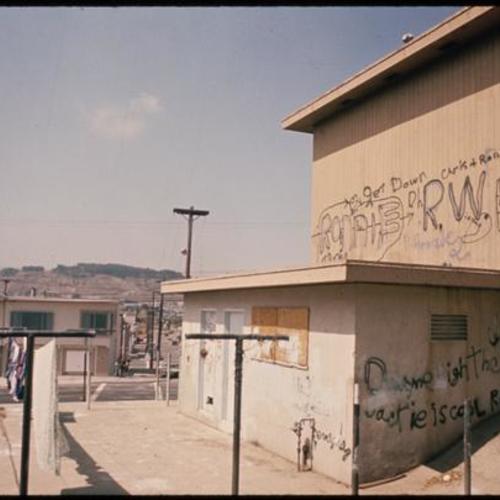 Exterior of withered building with graffiti and laundry hanging outside