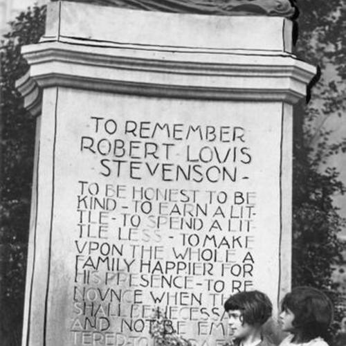 [Two little girls reading the words inscribed on the Robert Louis Stevenson monument]