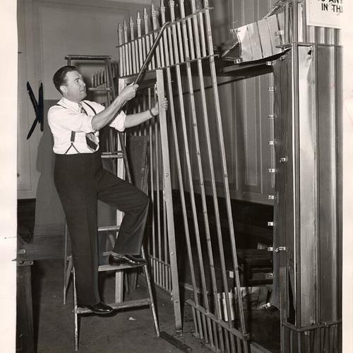 [Judge Daniel Shoemaker assisting Bert Whelan (top ladder) to remove the prisoners cage in Old Hall of Justice]
