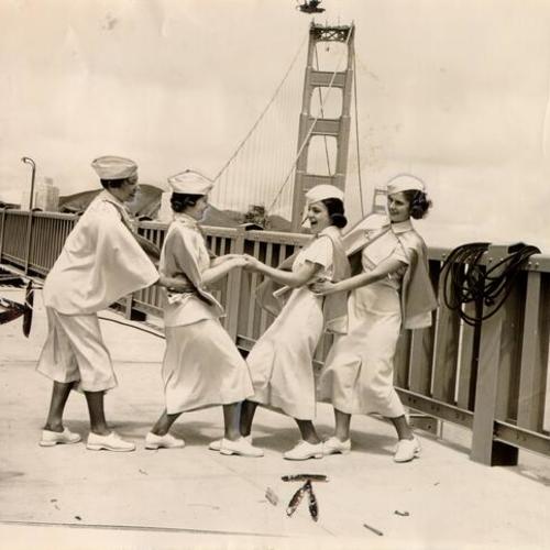 [Members of the Girls High School Singers celebrating at a ceremony marking the driving of the last rivet during construction of the Golden Gate Bridge]